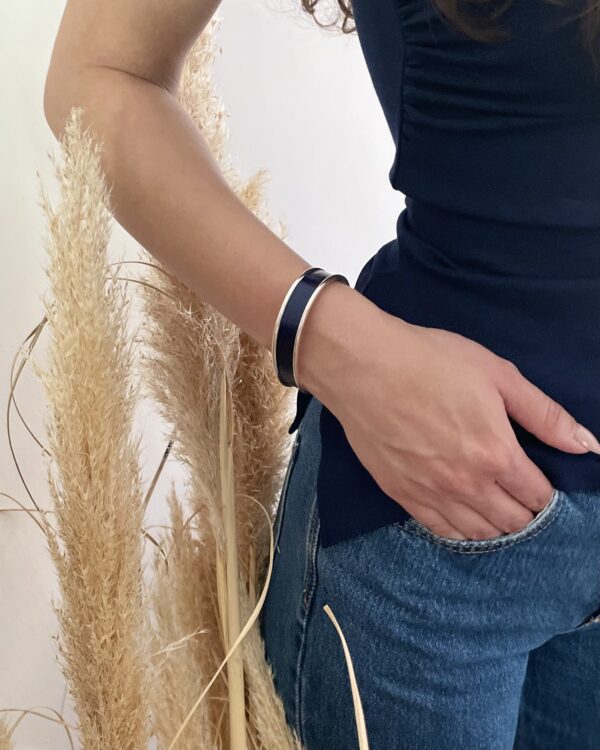 Vue rapprochée d’un bracelet bleu en marqueterie de paille porté au poignet
